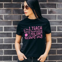 a woman wearing a black t - shirt that says i teach so you can't save me
