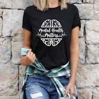 a woman wearing a black t - shirt that says mind health matters
