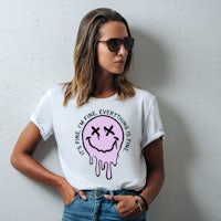 a woman wearing a white t - shirt with a smiley face on it