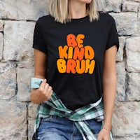 a woman wearing a t - shirt that says be kind brush