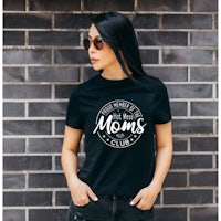 a woman wearing a black t - shirt with the words moms club
